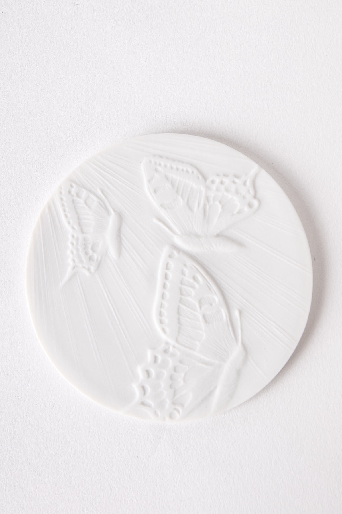 cabochon-blanc-grave-motif-papillon-memoire-de-porcelaine cabochon gravé à motif de papillon sur l'urne funéraire en porcelaine
